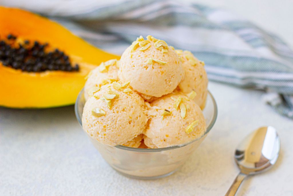 Banana Papaya Protein Ice Cream with papaya in a glass bowl