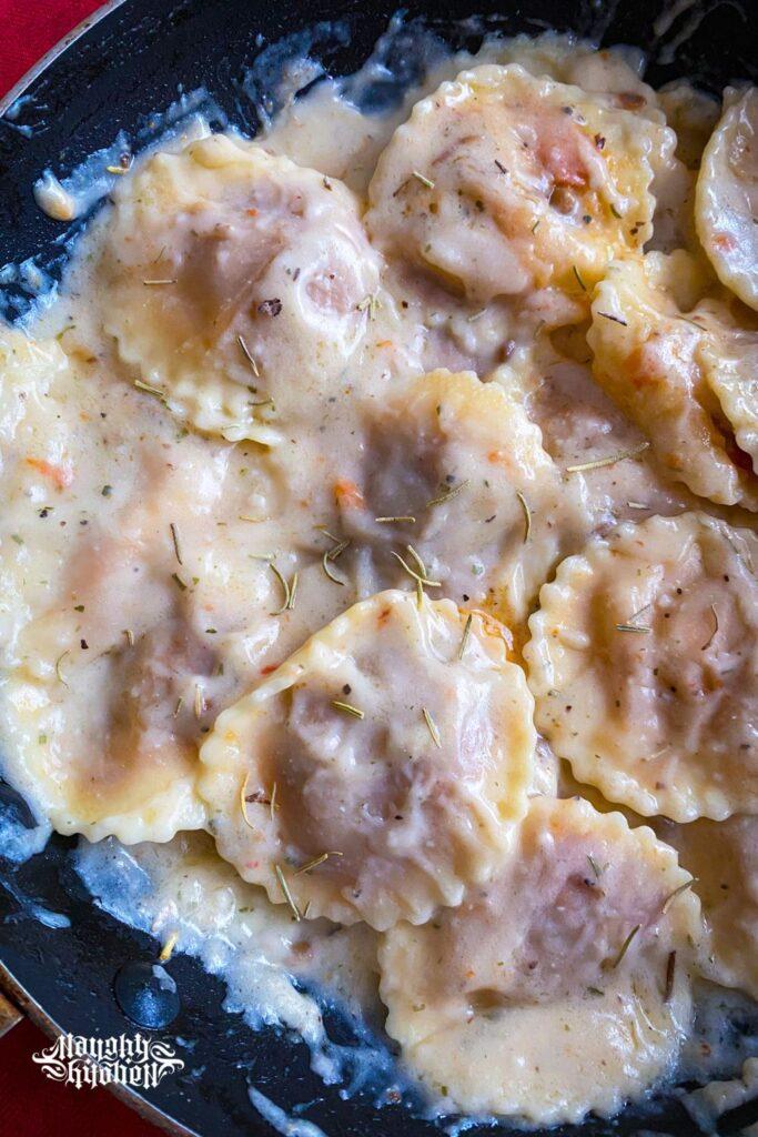 plant based ravioli in herb infused white sauce in a pan