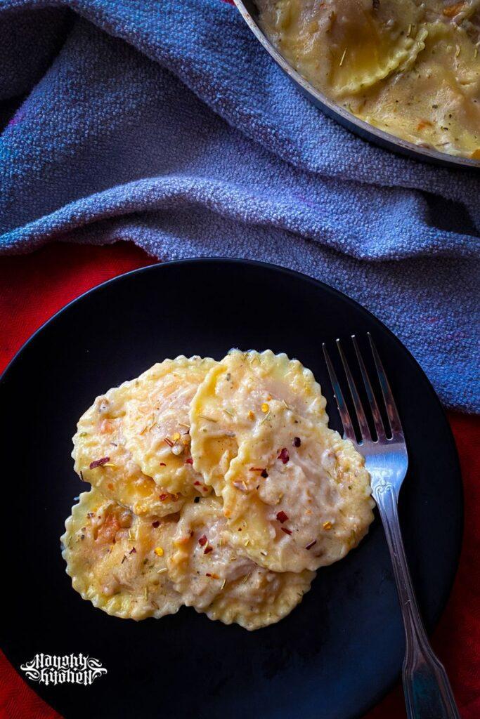 plant based ravioli in herb infused white sauce with fork