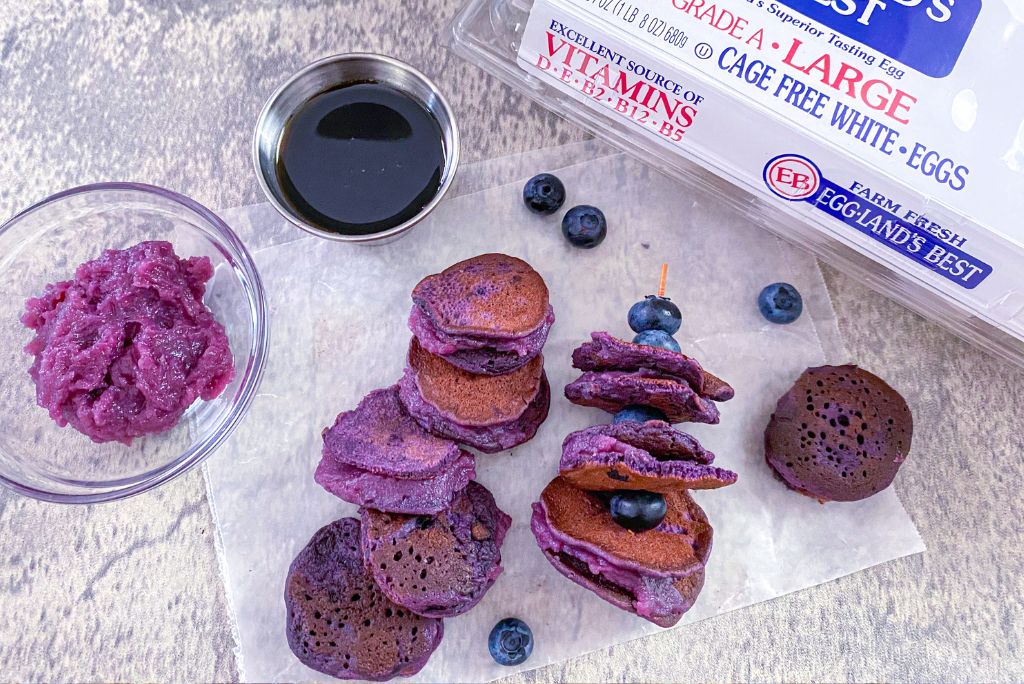 Ube Pancake Coins with blueberries and Eggland's Best Cage Free Eggs