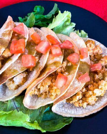 Crispy Potato Tacos with tomatoes and hot sauce.