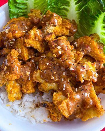 Almond Butter Tofu with rice and lettuce in a white bowl.