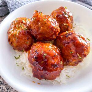 Honey Sriracha Turkey Meatballs in a white bowl with rice.