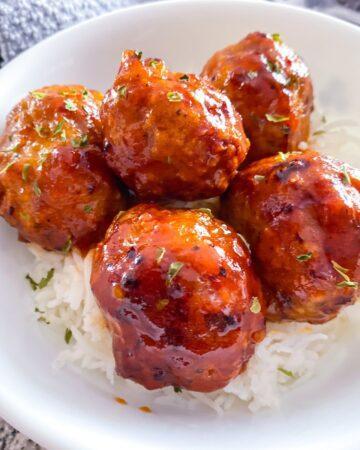 Honey Sriracha Turkey Meatballs in a white bowl with rice.