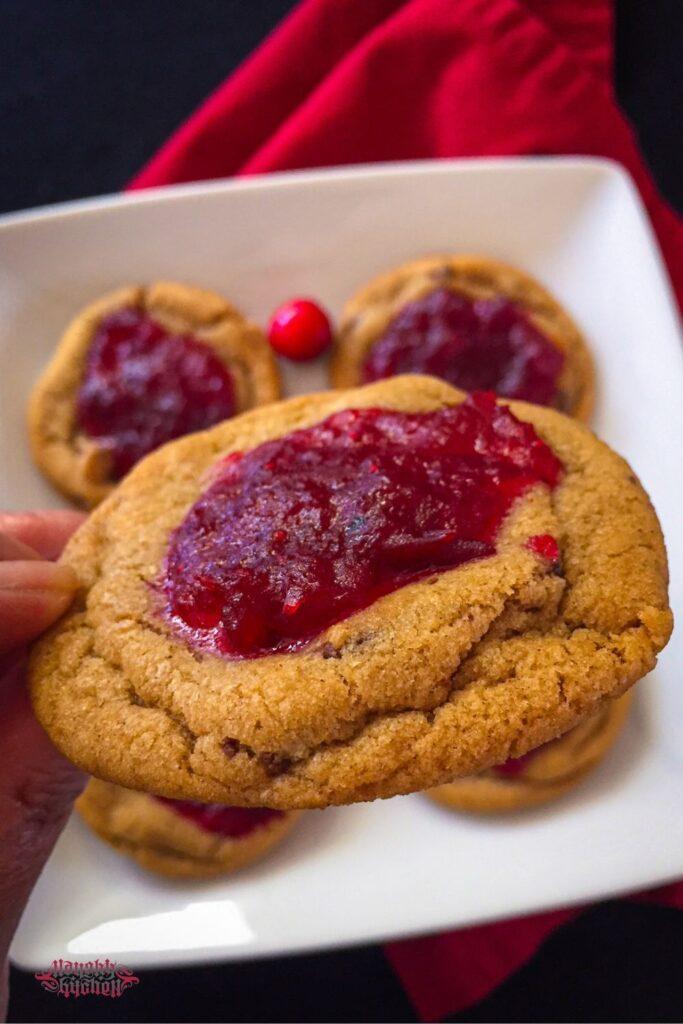 Holding a piece of Cranberry jam chocolate chip cookie.