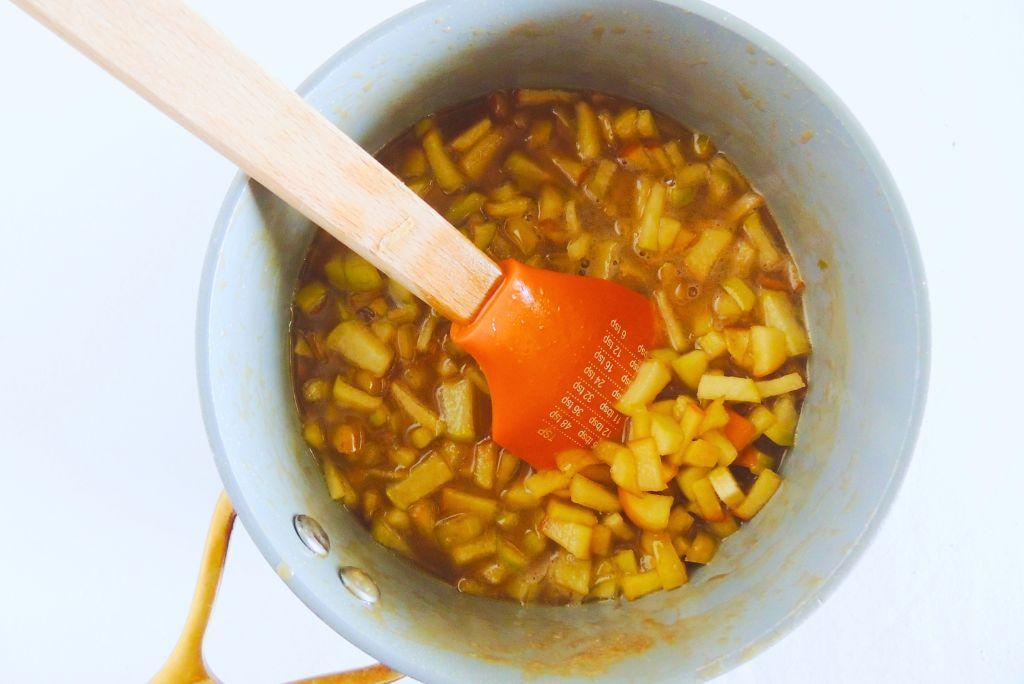 Caramel apples in a sauce pan.