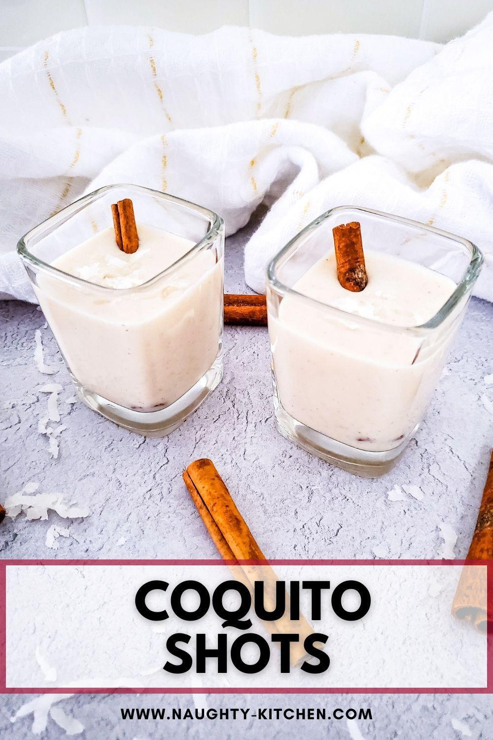 Coquito in shot glasses with cinnamon sticks.