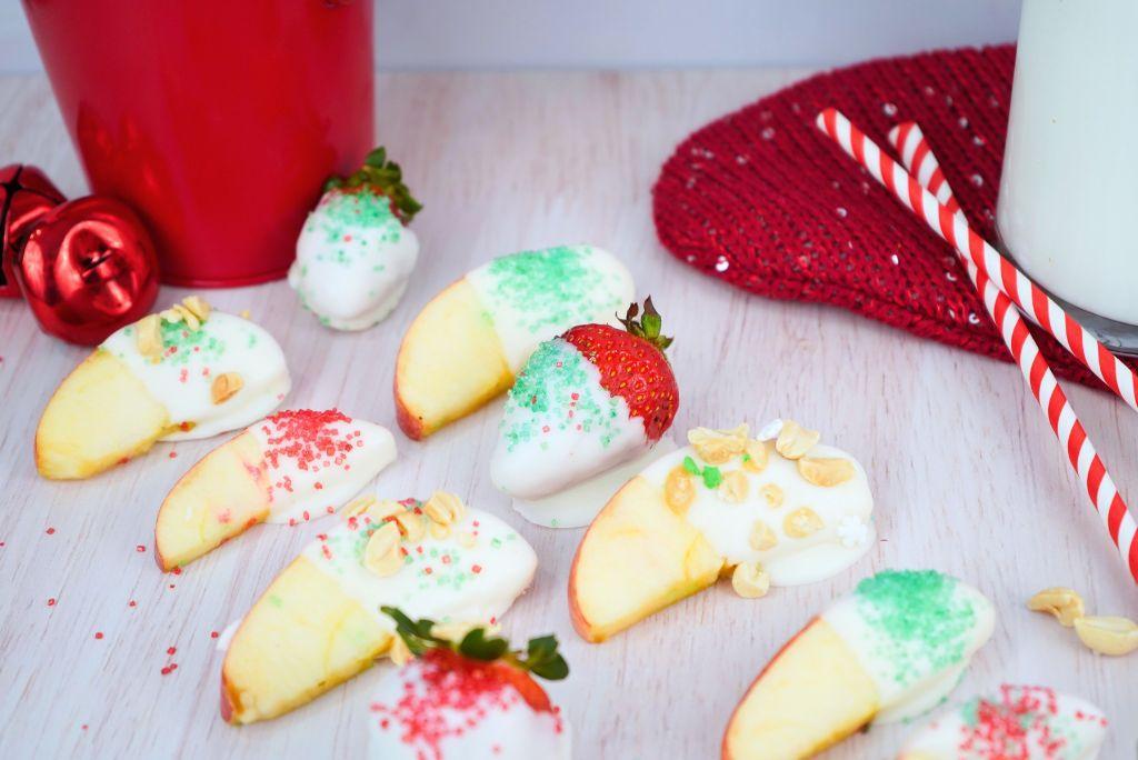 Holiday Dipped Apples and Strawberries with holiday sprinkles.