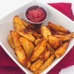 oven roasted red potato wedges in a white bowl.