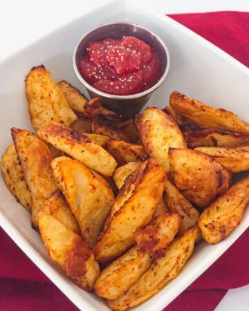 oven roasted red potato wedges in a white bowl.