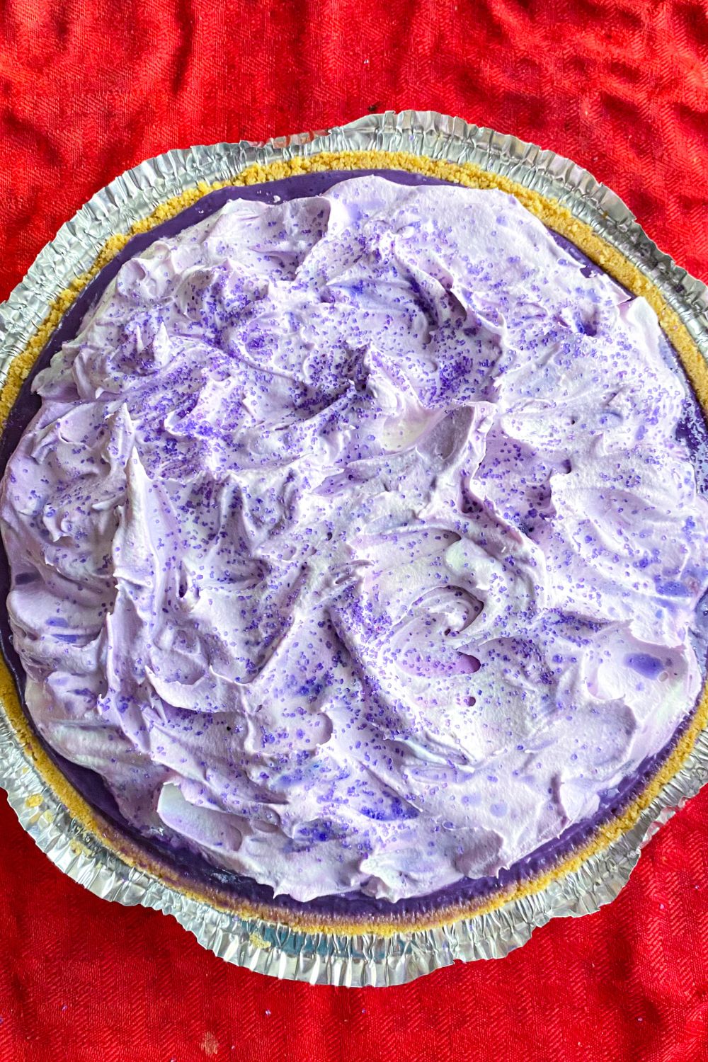 Whole ube lush pudding pie with sugar sprinkles.