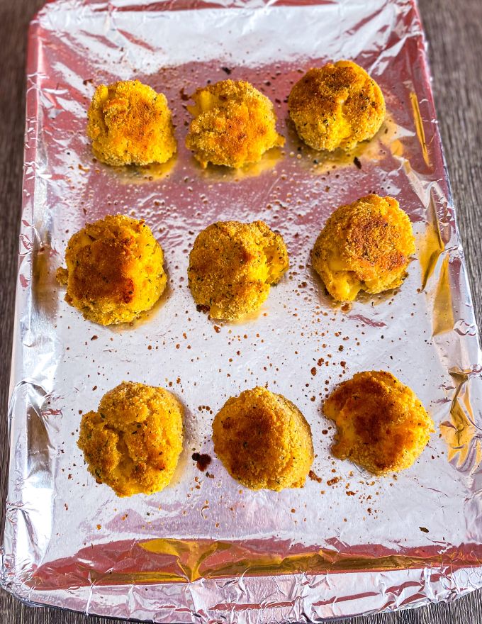 Mac and cheese bites on a baking sheet with foil.