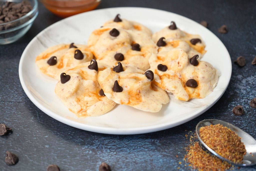 Frozen Greek yogurt banana bites topped with caramel and chocolate chips
