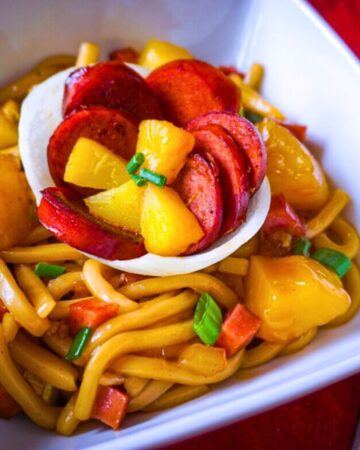 Hawaiian sausage noodles with pineapple chunks and green onions in glossy sweet and savory sauce