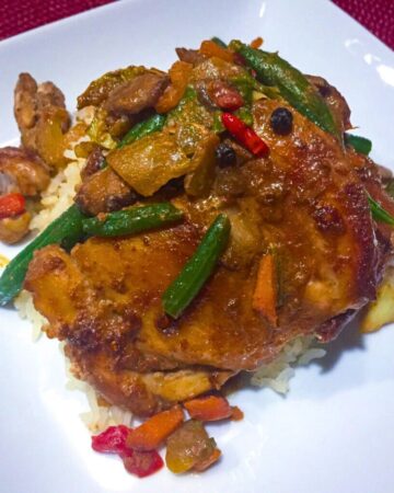 Filipino chicken adobo stir fry with golden brown chicken thighs in glossy adobo sauce served over white rice